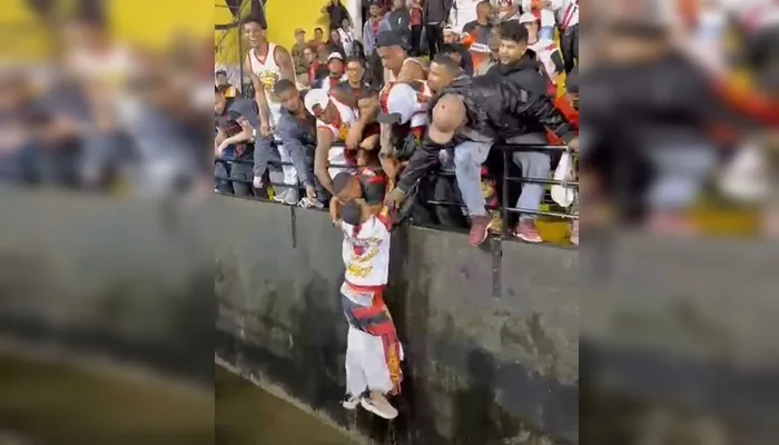 Torcedor do Vitória pula em fosso de estádio para pegar jaqueta, e torcida vibra com retorno — Foto: Manuela Silva