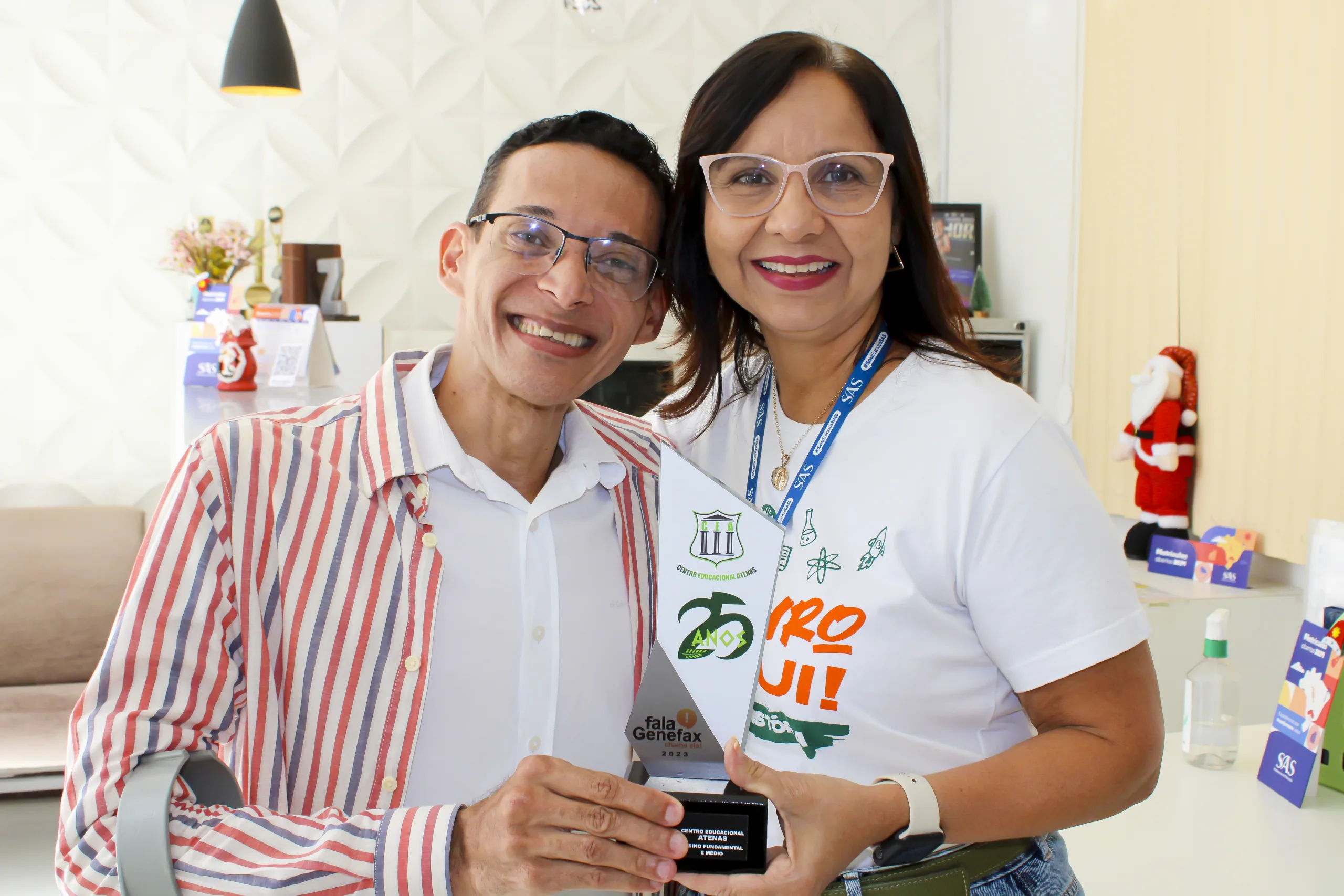 Jornalista Genefax entrega troféu a Cleuma Felix, diretora da instituição. Foto: FALA GENEFAX