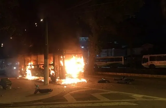 Ônibus envolto em chamas durante protestos violentos após a queda do Santos para a Série B do Campeonato Brasileiro. - Foto: Silvio Luiz/G1