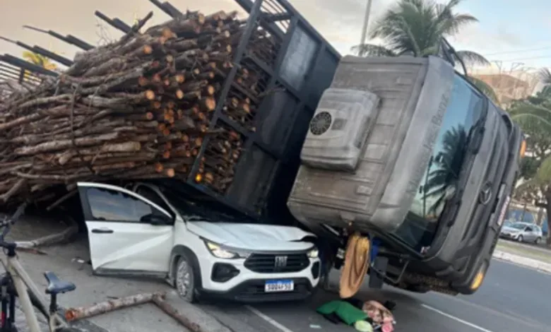 carga de madeira cai em carro